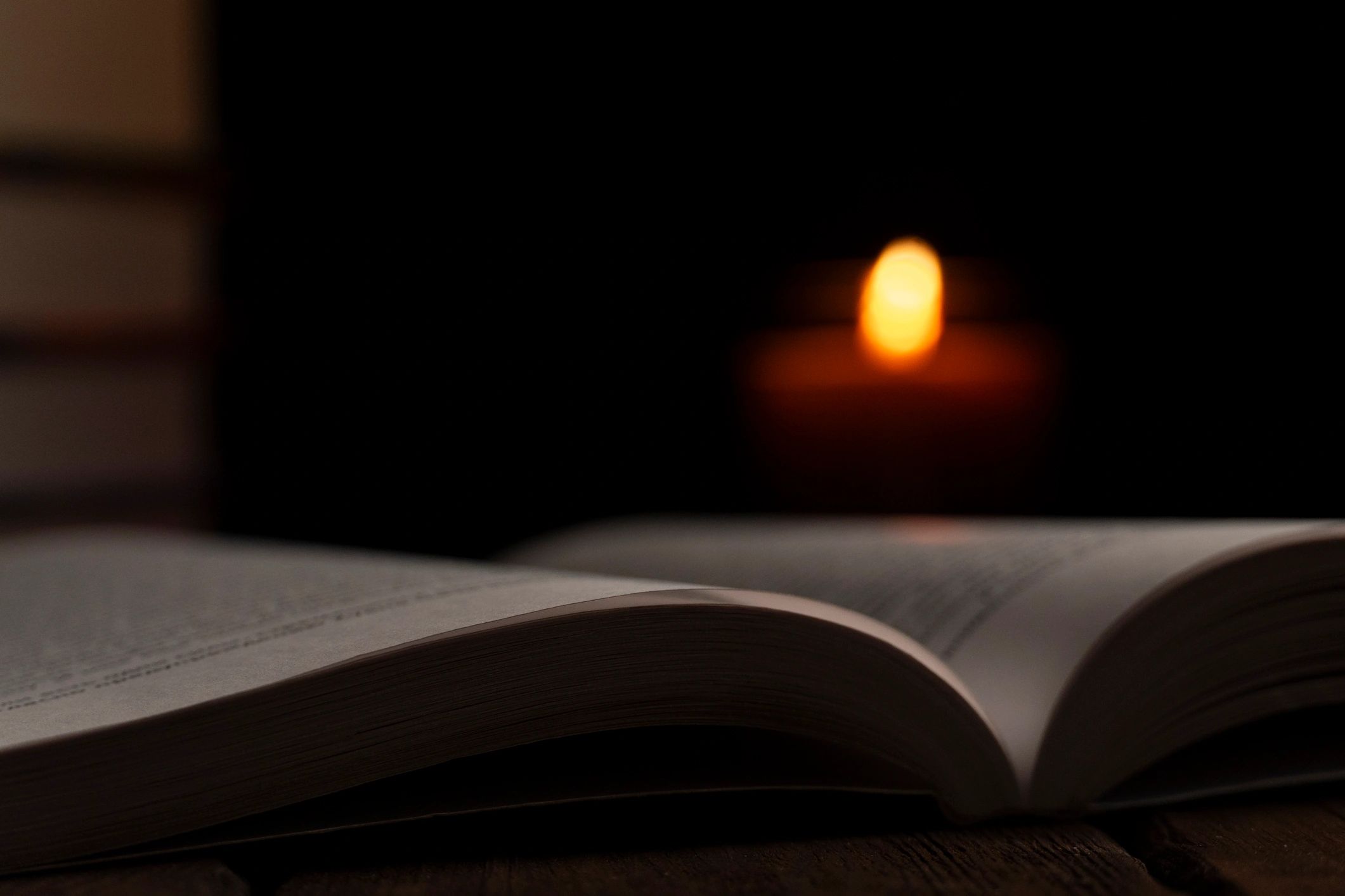 Open prayer book in warm candlelight
