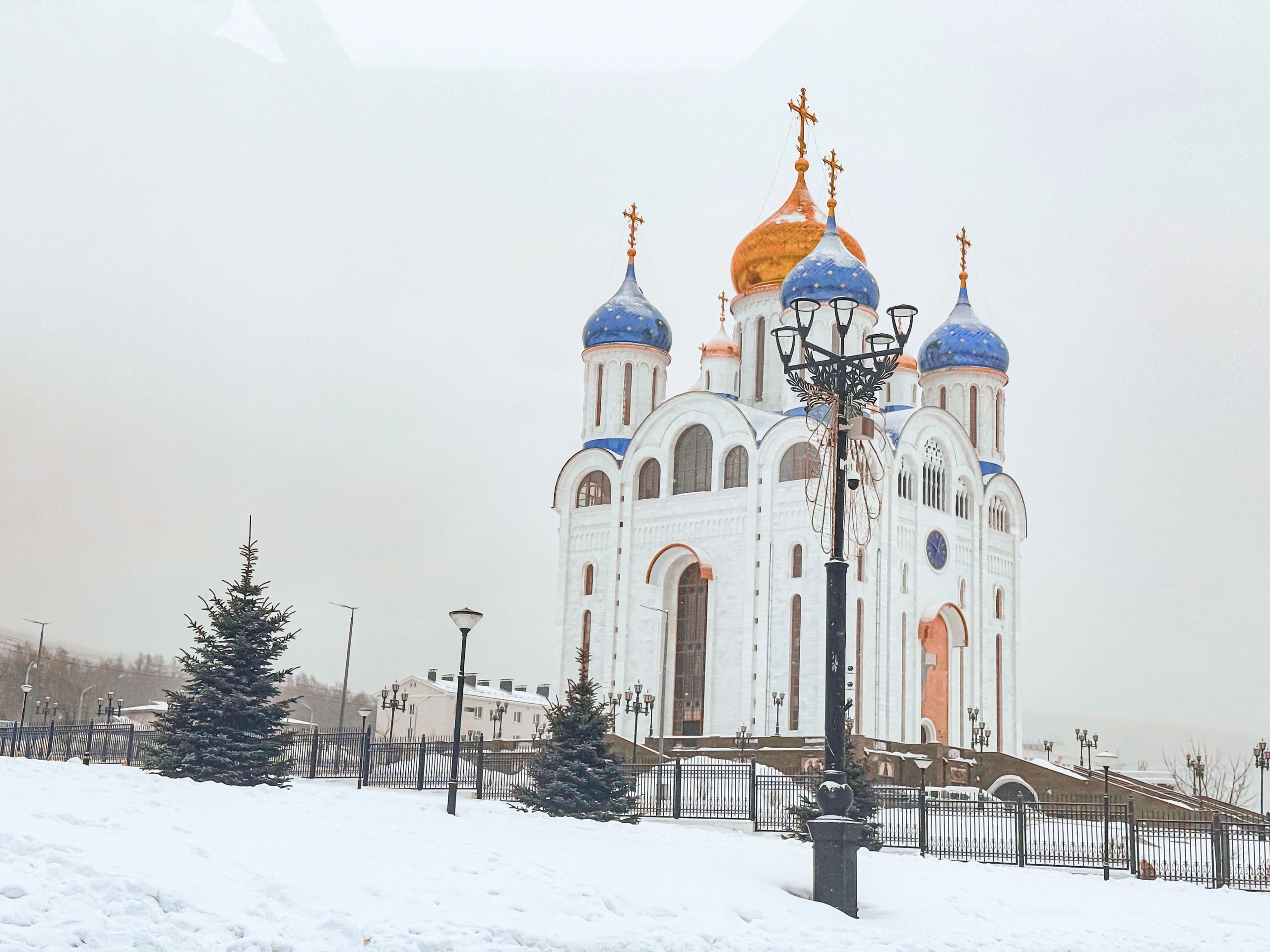 Orthodox church with blue and gold onion domes in winter